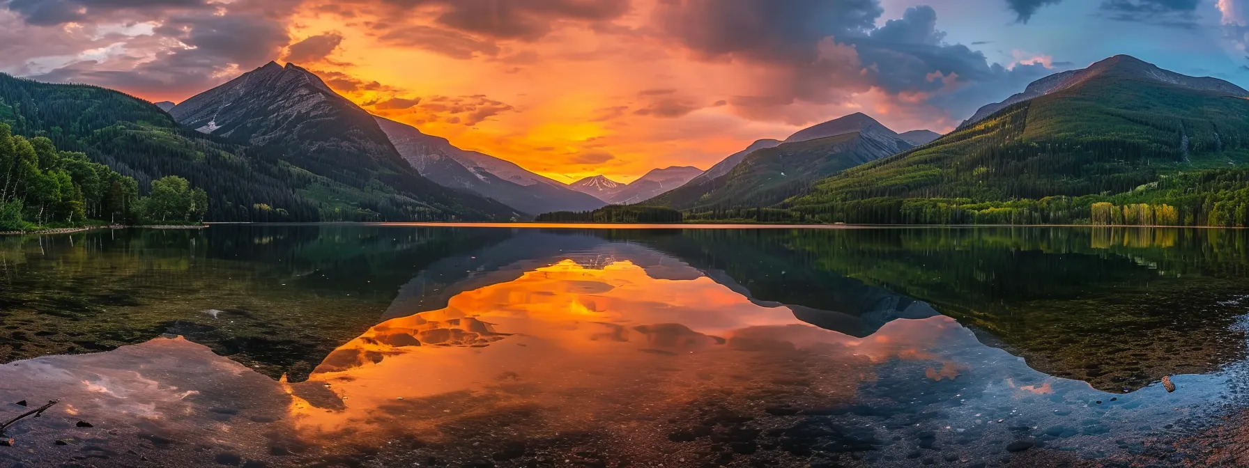 a breathtaking sunset casts a warm golden glow over a tranquil lake surrounded by majestic mountains, reflecting the vibrant colors of the sky in its still waters.