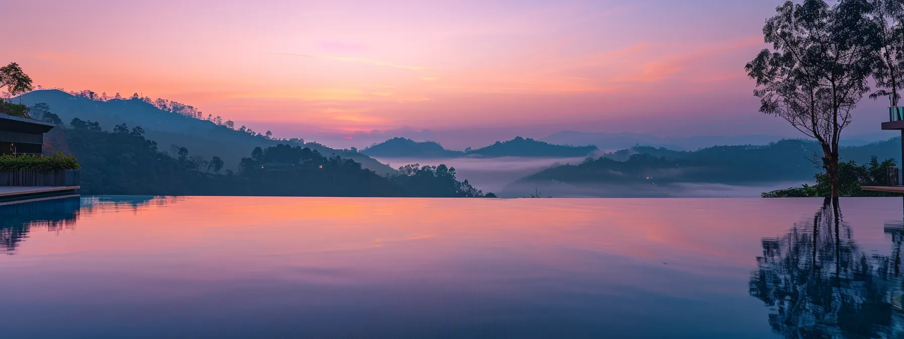 a breathtaking sunset casts vibrant hues of orange and pink over a tranquil lake, reflecting the stunning panorama of surrounding misty mountains.
