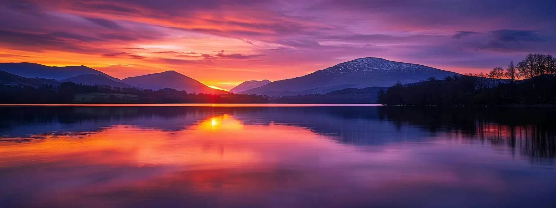 a breathtaking sunset casts vibrant hues across a serene lake, reflecting the fiery oranges and deep purples of the sky, while majestic mountains loom in the background under a gently fading light.