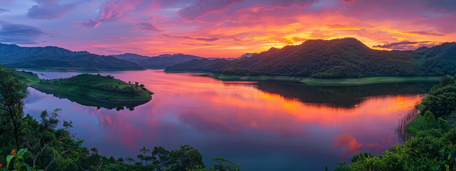 a panoramic view of a vibrant sunset painting the sky in brilliant shades of orange and pink, reflecting off a serene lake surrounded by lush, green mountains.