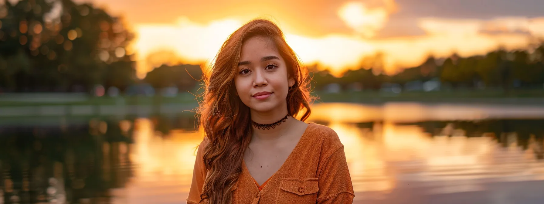 a vibrant sunrise casts a golden glow over a tranquil lake, where the shimmering water mirrors the colorful sky, creating a serene atmosphere that invites contemplation.