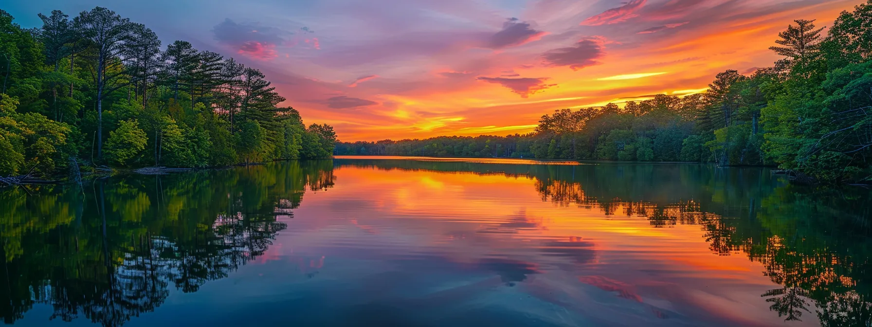 a vibrant sunset casts a warm golden glow over a serene lake, reflecting the colorful sky and surrounded by lush green trees, creating a tranquil and picturesque landscape.