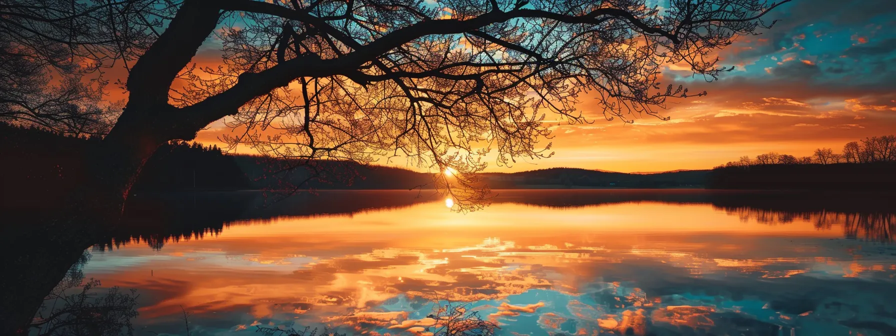 a vibrant sunset casts a warm golden hue over a tranquil lake, reflecting a kaleidoscope of colors while silhouetted trees frame the serene landscape.
